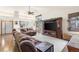 Open-concept living room with hardwood floors, a ceiling fan, and a seamless transition to the kitchen at 1181 E 130Th Pl, Thornton, CO 80241