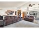 Spacious living room featuring comfortable seating, a ceiling fan, stylish decor, and a seamless transition to the kitchen at 1181 E 130Th Pl, Thornton, CO 80241