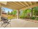 Covered patio with metal chairs and table, looking out onto a fenced yard at 1181 E 130Th Pl, Thornton, CO 80241