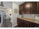 Dry bar with stone backsplash and wood cabinets that overlooks the open living area at 2349 Hickory Pl, Erie, CO 80516