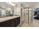 Modern bathroom with a glass enclosed shower and dark wood vanity with light countertops at 2349 Hickory Pl, Erie, CO 80516