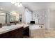 Bright bathroom featuring a soaking tub with tile surround and a double sink vanity at 2349 Hickory Pl, Erie, CO 80516