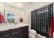Clean bathroom with a dark vanity, patterned shower curtain, and bright overhead lighting at 2349 Hickory Pl, Erie, CO 80516