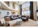 Bright and airy living room with a large sectional sofa, a fireplace, and expansive windows overlooking the beautiful outdoors at 2349 Hickory Pl, Erie, CO 80516