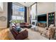 Grand living room with high ceilings, large windows, and a cozy fireplace at 2349 Hickory Pl, Erie, CO 80516