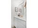 Bright half bathroom with a clean white vanity, gold faucet, and decorative wall art at 8773 W Cornell Ave # 10, Lakewood, CO 80227
