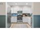 Well-lit kitchen with stainless steel appliances, white cabinetry, and blue backsplash at 8773 W Cornell Ave # 10, Lakewood, CO 80227