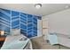 Bedroom displaying a blue accent wall with white geometric designs and two beds with grey blankets at 334 Green Rock Pl, Monument, CO 80132