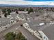 An elevated view of townhomes with private garages, manicured lawns, and architectural details with mountain backdrop at 8621 E Dry Creek Rd # 325, Englewood, CO 80112
