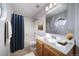 Cozy bathroom with blue shower curtain, wood vanity, and round window at 8621 E Dry Creek Rd # 325, Englewood, CO 80112