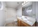 Simple bathroom with tub/shower, circular window, and wooden vanity with white top at 8621 E Dry Creek Rd # 325, Englewood, CO 80112
