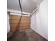 An empty garage with bare walls and a wooden sectional door at 8621 E Dry Creek Rd # 325, Englewood, CO 80112