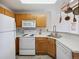 Bright kitchen with white appliances, wood cabinets, and neutral countertops at 8621 E Dry Creek Rd # 325, Englewood, CO 80112