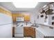 Charming kitchen featuring a pot rack, white appliances, and easy living space flow at 8621 E Dry Creek Rd # 325, Englewood, CO 80112