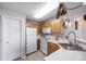 Functional kitchen space with light wood cabinets, white appliances, and a pot rack feature at 8621 E Dry Creek Rd # 325, Englewood, CO 80112