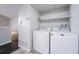 A bright laundry room with a washer, dryer and open shelf at 8621 E Dry Creek Rd # 325, Englewood, CO 80112
