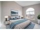 Beautifully staged main bedroom with large window, gray walls, and a blue and white color scheme at 8621 E Dry Creek Rd # 325, Englewood, CO 80112