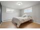 Clean bedroom with wood floors, two windows, and a comfortable bed at 11845 W 30Th Pl, Lakewood, CO 80215