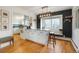Kitchen with island, modern light fixture, hardwood floors, and dark accent wall at 11845 W 30Th Pl, Lakewood, CO 80215