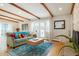 Bright living room with wood beams, hardwood floors, and a cozy fireplace at 11845 W 30Th Pl, Lakewood, CO 80215