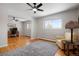 Spacious living room with hardwood floors, a ceiling fan, a large window, and a comfortable yellow chair at 11845 W 30Th Pl, Lakewood, CO 80215