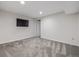 A well-lit basement area with neutral paint, carpet, and a television at 10290 W Jewell Ave # B, Lakewood, CO 80232