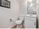 Small but charming bathroom with a white vanity, toilet, and framed art at 10290 W Jewell Ave # B, Lakewood, CO 80232