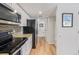 Kitchen and pantry lead to hallway and bathroom, featuring stainless steel appliances at 10290 W Jewell Ave # B, Lakewood, CO 80232
