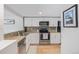 Well-lit kitchen with stainless steel appliances, granite countertops, and hardwood floors, perfect for cooking and entertaining at 10290 W Jewell Ave # B, Lakewood, CO 80232