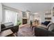 Bright living room featuring two couches, a fireplace, large windows with sheer curtains, and hardwood floors at 10290 W Jewell Ave # B, Lakewood, CO 80232