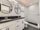 Updated bathroom with a double vanity, black countertop, and a tiled shower at 655 S Osceola St, Denver, CO 80219