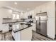 Modern kitchen boasts white cabinets, stainless steel appliances, and a center island at 655 S Osceola St, Denver, CO 80219