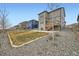 A spacious backyard with a wooden fence and a wooden stairway leading to a small deck at 140 Racer St, Bennett, CO 80102