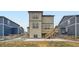 Backyard of the two-story home with a walkout patio, wooden staircase, and xeriscaping at 140 Racer St, Bennett, CO 80102