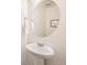 Bathroom pedestal sink with decorative mirror and towel holder at 140 Racer St, Bennett, CO 80102