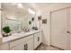 Bright bathroom featuring a double vanity with white cabinets and framed mirrors at 140 Racer St, Bennett, CO 80102