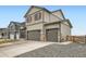 Two-story home with a 2-car garage with stone veneer and neutral color palette at 140 Racer St, Bennett, CO 80102