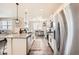 Open-concept kitchen with modern stainless appliances and a kitchen island at 140 Racer St, Bennett, CO 80102
