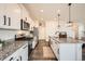 Open-concept kitchen with modern stainless appliances, granite counters, and an island at 140 Racer St, Bennett, CO 80102