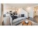 Open-concept living room features a view of the kitchen and staircase to the second floor at 140 Racer St, Bennett, CO 80102