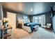 Carpeted main bedroom with blue accents, TV, and ensuite bathroom at 140 Racer St, Bennett, CO 80102