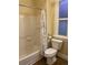 Bathroom features a shower-tub combo with a white shower curtain and a toilet next to a window at 3616 N Gilpin St, Denver, CO 80205