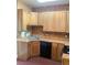 Kitchen featuring brick accent wall, stainless steel sink, wooden cabinets, and appliances at 3616 N Gilpin St, Denver, CO 80205
