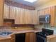 Cozy kitchen featuring wooden cabinets, brick accent wall, and stainless steel appliances at 3616 N Gilpin St, Denver, CO 80205