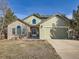 Two-story house with brick and siding, attached garage, and landscaped yard at 1663 Devils Point Pl, Highlands Ranch, CO 80126