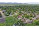 Aerial view of a home with a large yard, a pool, and mature trees in a residential neighborhood at 13270 W 65Th Ave, Arvada, CO 80004