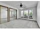 Bright bedroom featuring a large window array, mirrored closet, neutral carpet, and a ceiling fan at 13270 W 65Th Ave, Arvada, CO 80004