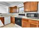 Kitchen with wood cabinets and a white dishwasher, oven, and microwave at 13270 W 65Th Ave, Arvada, CO 80004