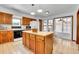 Bright kitchen featuring an island, appliances, and access to the sunroom at 13270 W 65Th Ave, Arvada, CO 80004