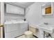 Functional laundry room features a washer, dryer, storage cabinets, a sink and a toilet for added convenience at 13270 W 65Th Ave, Arvada, CO 80004